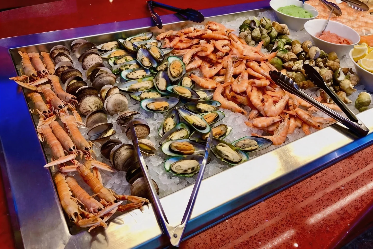 Prawns, mussels and langoustines on ice at the buffet, stainless-steel tongs