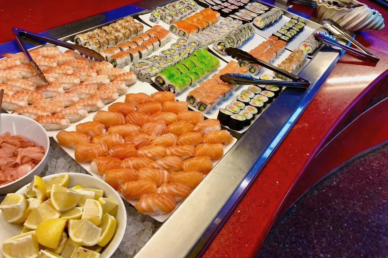 Sushi and maki at the buffet, bowls of lemon on ice
