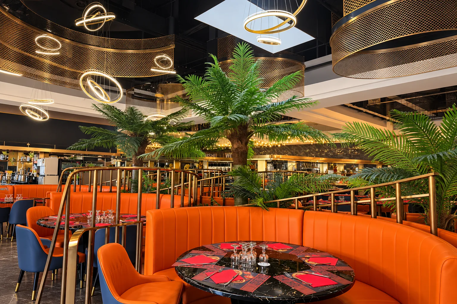 Curved orange banquette, set round table and palm trees